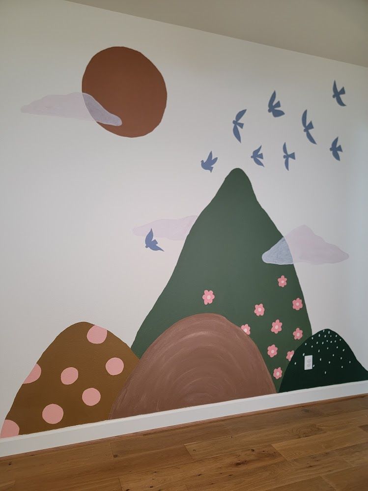 Hand-painted nursery mural with mountains, sun, and birds